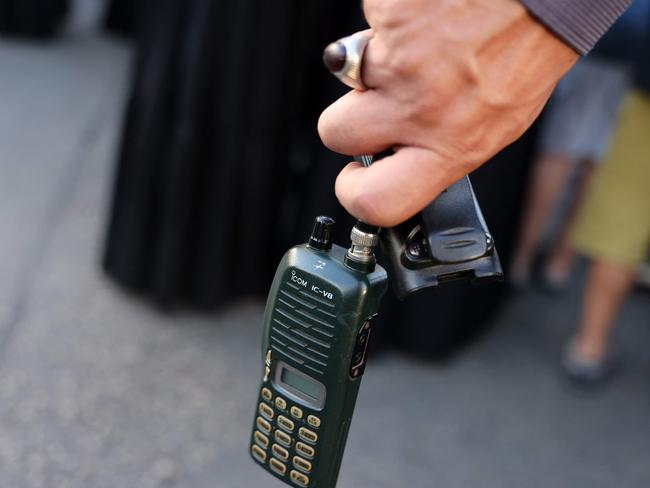 A man holds a walkie talkie device after he removed the battery during the funeral of people killed when hundreds of paging devices exploded in a deadly wave across Lebanon. Picture: AFP