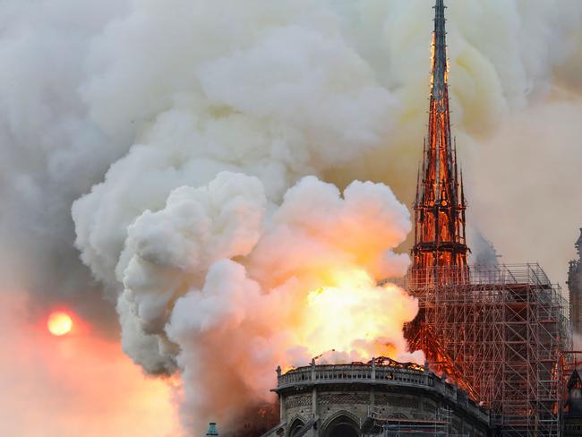 TOPSHOT - Smoke and flames rise during a fire at the landmark Notre-Dame Cathedral in central Paris on April 15, 2019, potentially involving renovation works being carried out at the site, the fire service said. - A major fire broke out at the landmark Notre-Dame Cathedral in central Paris sending flames and huge clouds of grey smoke billowing into the sky, the fire service said. The flames and smoke plumed from the spire and roof of the gothic cathedral, visited by millions of people a year, where renovations are currently underway. (Photo by FRANCOIS GUILLOT / AFP)