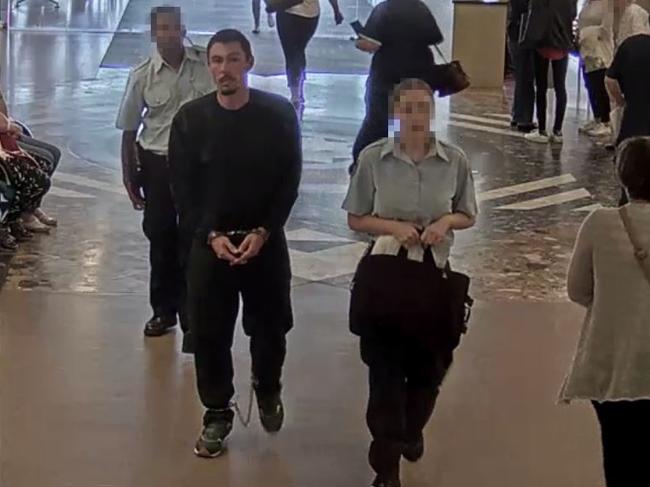 A handcuffed and shackled Siimon John Way is escorted by two guards to the John Hunter Hospital’s emergency room in Newcastle.