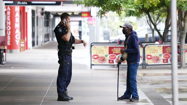 A police officer talks to an indigenous man about the lockdown rules in Cairns. Picture: Brendan Radke