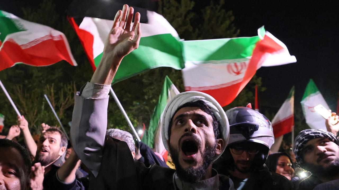 Demonstrators wave Iran's flag and Palestinian flags as they gather in front of the British Embassy in Tehran. Picture: AFP