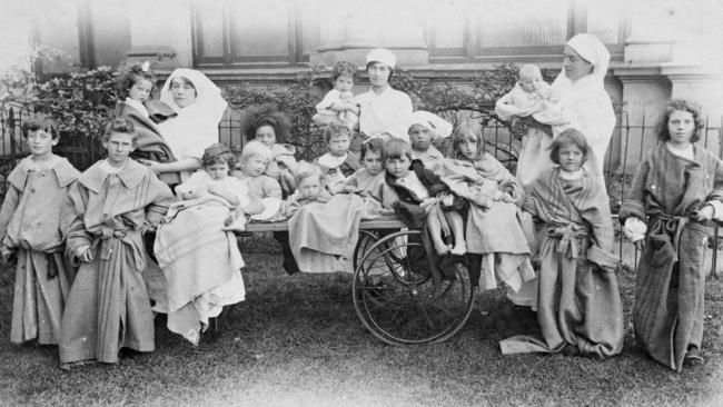 Nursing staff with young patients outside the Melbourne Exhibition Building in 1919. Picture: Museums Victoria.