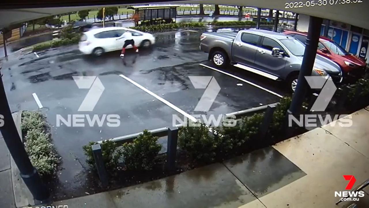 The mother sees her car leaving, with the baby inside, and frantically chases it out of the car park Picture: Channel 7