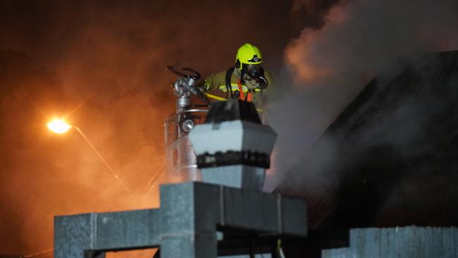 A firefighter in a cherry picker battles the blaze. Picture: Sam Yeomans