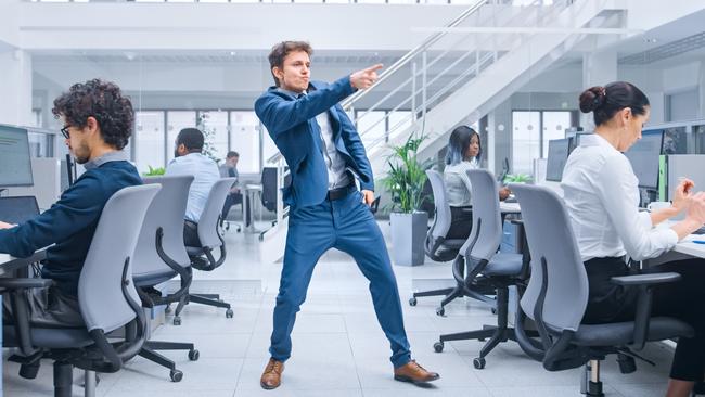 Young Cheerful Handsome Business Manager Wearing a Suit and Tie is Dancing like Crazy in the Office.Business People Work on Computers in Modern Open Office. Tax party generic