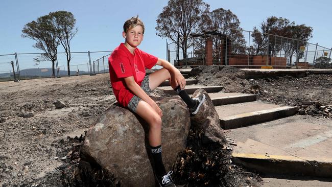 Jake, 10, at what remained of Clifton Creek Primary School after fires in East Gippland. Picture: David Geraghty