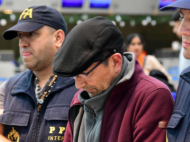 Former Argentine police officer Mario Sandoval is escorted by police officers upon his arrival at Ezeiza airport in Buenos Aires after France extradited him to face trial over the disappearance of a student. Picture: AFP