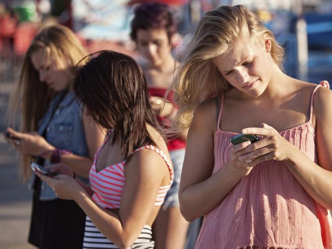 Teenagers using smart phones. Thinkstock