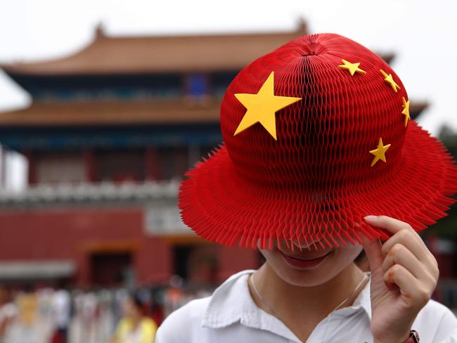 A women wears a bright red hat, covered with yellow stars in the style of the People's Republic of China's national flag, also known as the Five-star Red flag as she visits the Forbidden City in Beijing, China, on Thursday, July 28, 2016. As China's travel market takes off, all eyes should be on the country's roughly 400 million millennials, who will drive spending on airfare, hotels, theme parks, casinos and cruises. Photographer: Luke MacGregor/Bloomberg