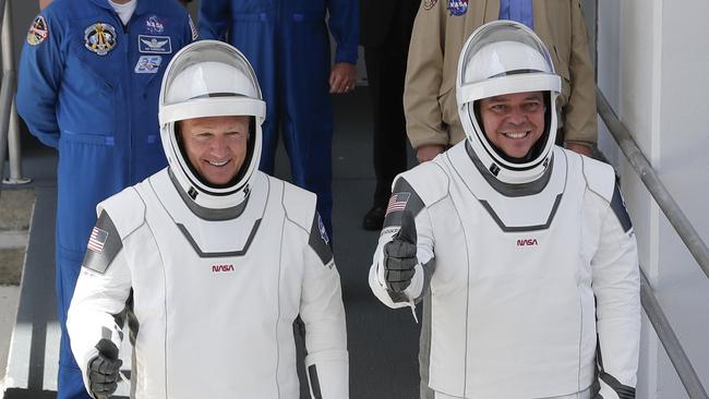 NASA astronauts Douglas Hurley, left, and Robert Behnken walk out of the Neil A. Armstrong Operations and Checkout Building on their way to Pad 39-A.