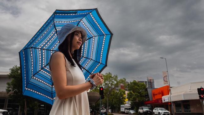 Ngoc Pham holds an umbrella after the first rain of the wet season drenched Darwin overnight. Picture: Pema Tamang Pakhrin