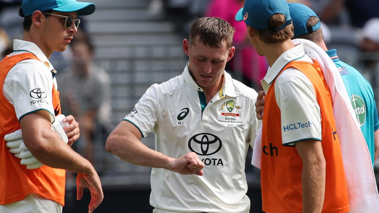 Marnus Labuschagne inspects his injured finger (Photo by COLIN MURTY / AFP) /