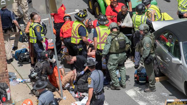 People receive first-aid after a car mowed down a crowd of protesters last August. Picture: AFP Photo / Paul J. Richards