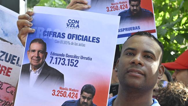 A man displays a banner with the results of Venezuela's July 28 presidential election, according to the opposition, as he gathers in support of Venezuelan opposition leader Edmundo Gonzalez Urrutia.