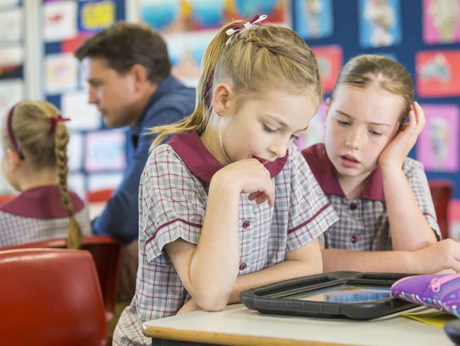 Happy smiling young school girl using a high technology wireless tablet computer in the classroom Picture: Istock