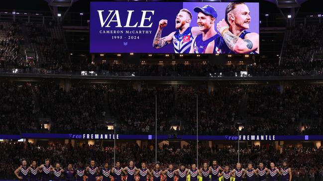 The teams pay their respects to former player Cam McCarthy. (Photo by Paul Kane/Getty Images)