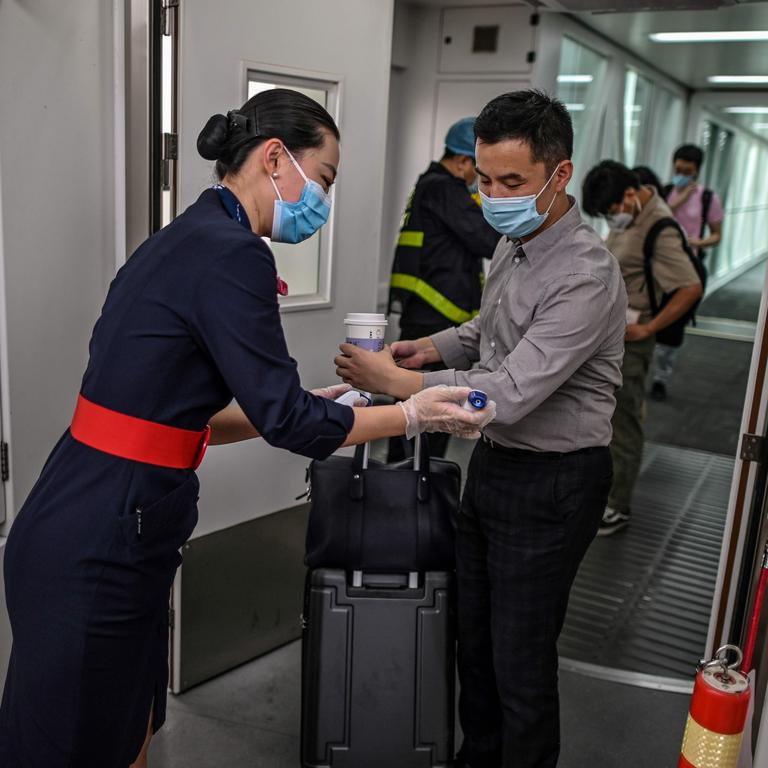 A flight attendant checking someone’s body temperature. Picture: Hector Retamal/AFP