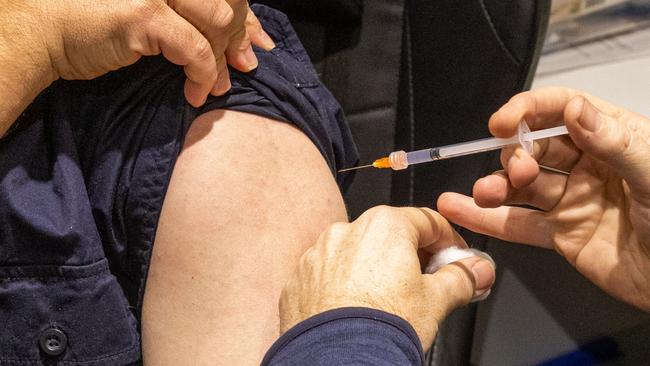 MELBOURNE, AUSTRALIA - JULY 11: A pharmacist administers a COVID-19 vaccination booster shot to a customer at Exhibition Pharmacy on July 11, 2022 in Melbourne, Australia. More Australians are now eligible to receive a fourth dose of a COVID-19 vaccine, after the Australian Technical Advisory Group on Immunisation (ATAGI) approved people aged 30 and above can access additional booster shots from Monday 11 July. While over 30s are now eligible for an additional dose if they choose, health authorities are strongly urging people over 50 to get the fourth COVID-19 vaccine booster and for people to wear masks indoors in public as coronavirus infections continue driven by Omicron subvariants. (Photo by Asanka Ratnayake/Getty Images)