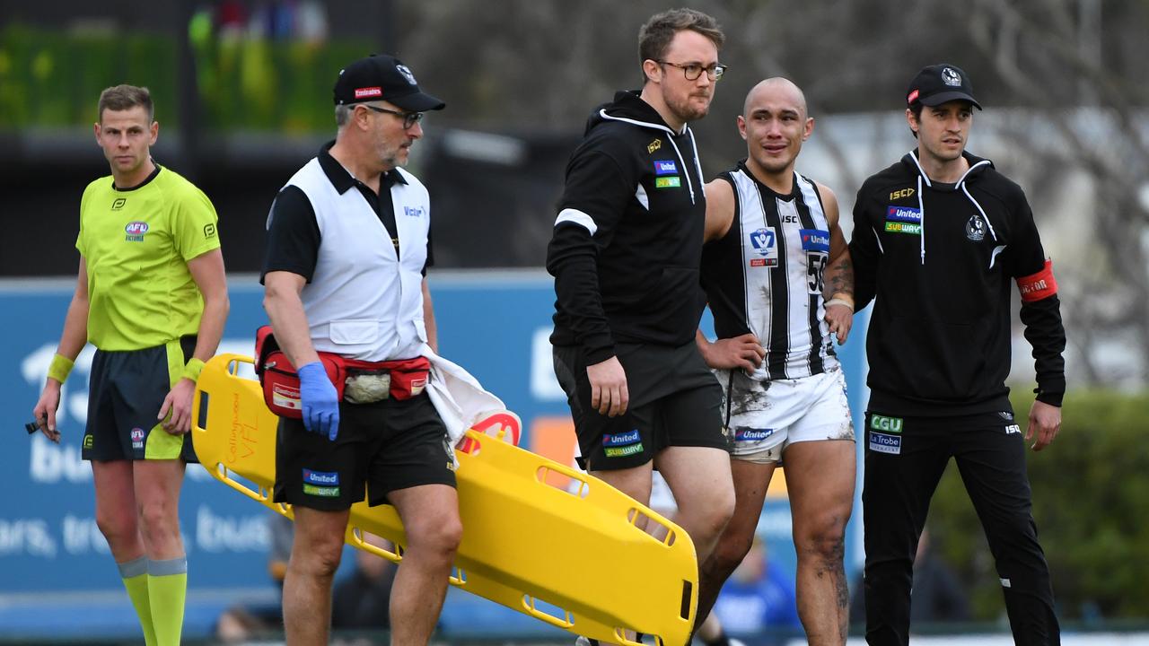 Alex Woodward is helped off the ground after appearing to suffer a fifth ACL injury. (AAP Image/James Ross)