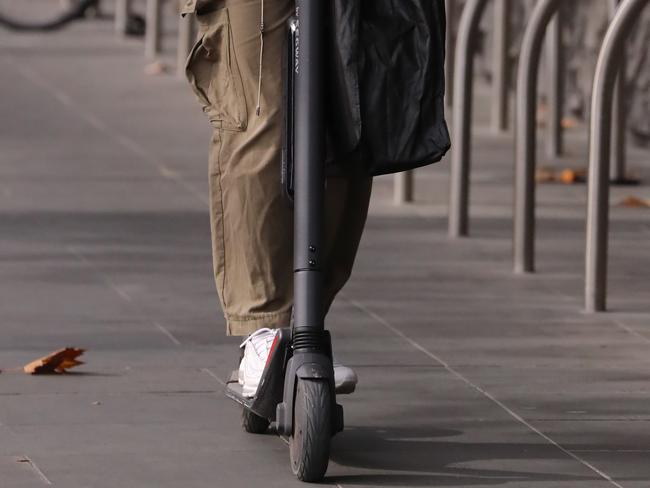 People out and about in Melbourne wearing masks and adhering, or not adhering, to social distancing rules. A man on a scooter in Melbourne CBD. Picture: Alex Coppel.