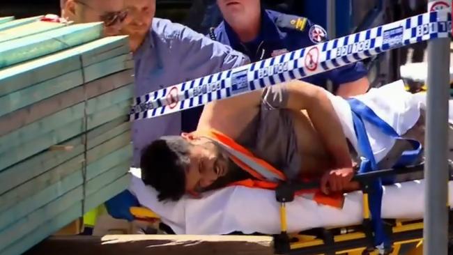 Antony Metledge writhes in pain as he is taken by paramedics with a knife still in his back. Picture: Nine News