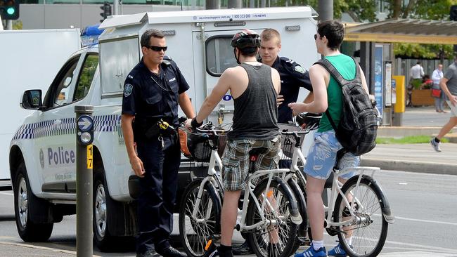 Cyclist using the footpath around the city. A tourists (right) gets spoken to for not wearing a helmet on King William St. by police officers.