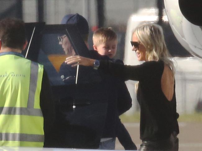 The family climbs into a waiting car at Sydney.