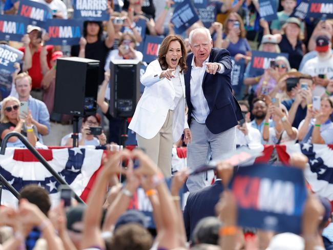 TOPSHOT - US Vice President and 2024 Democratic presidential candidate Kamala Harris and her running mate Minnesota Governor Tim Walz wave to supporters as they depart after speaking during a campaign rally in Eau Claire, Wisconsin, August 7, 2024.  (Photo by KAMIL KRZACZYNSKI / AFP)