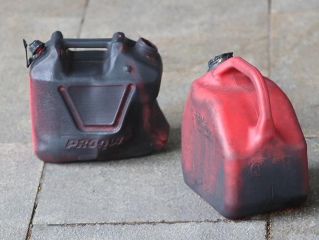 Charred jerry cans left outside the store. Picture: David Crosling