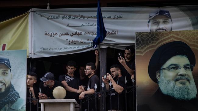 Men wait at the towns cemetery for the arrival of the coffin of Hezbollah fighter Husein Mohamad Choukair who was killed in an Israeli drone strike in southern Lebanon.