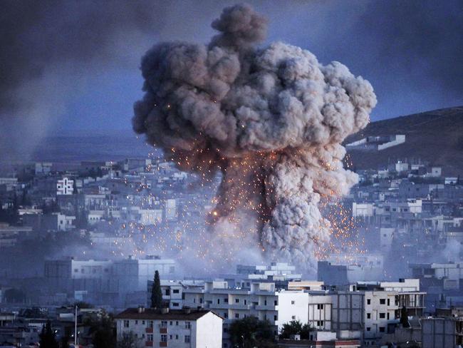 SANLIURFA, TURKEY - OCTOBER 20: (TURKEY OUT) An explosion rocks Syrian city of Kobani during a reported suicide car bomb attack by the militants of Islamic State (ISIS) group on a People's Protection Unit (YPG) position in the city center of Kobani, as seen from the outskirts of Suruc, on the Turkey-Syria border, October 20, 2014 in Sanliurfa province, Turkey. According to Foreign Minister Mevlut Cavusoglu, Turkey will reportedly allow Iraqi Kurdish fighters to cross the Syrian border to fight Islamic State (IS) militants in the Syrian city of Kobani while the United States has sent planes to drop weapons, ammunition and medical supplies to Syrian Kurdish fighters around Kobani. (Photo by Gokhan Sahin/Getty Images)