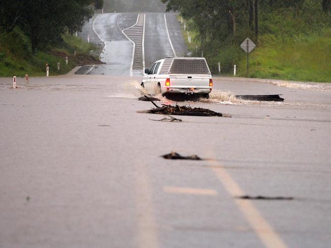 A car crossing a flooded section of the Bruce Highway.