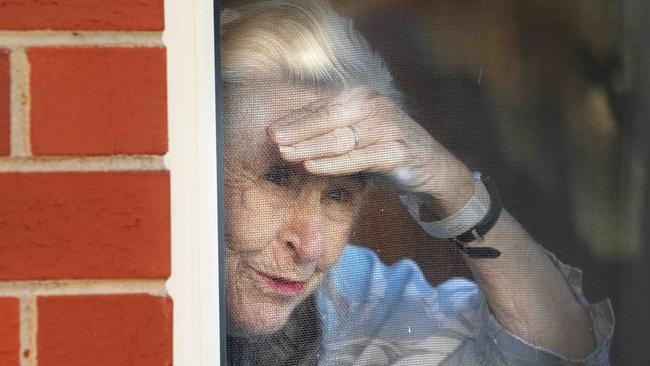 A resident peers out the window of the Coppin Centre in Footscray, Melbourne, on Monday. Picture: Tony Gough