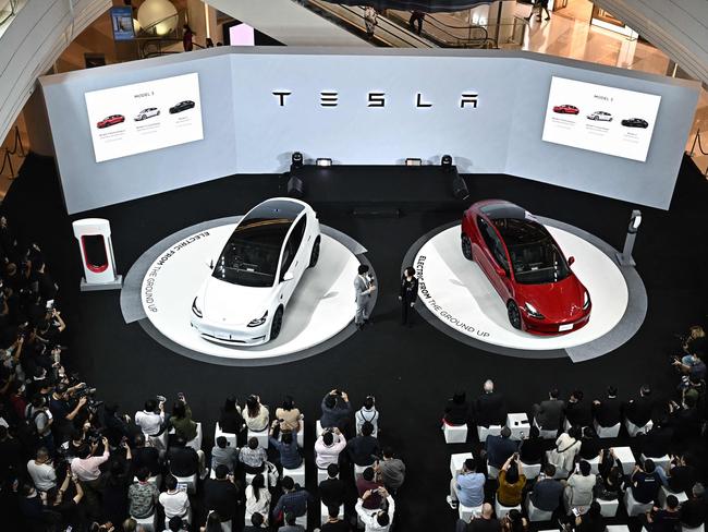 The Tesla Model Y (L) and the Tesla Model 3 (R) electric cars are unveiled during Tesla's official launch event in Bangkok on December 7, 2022. (Photo by Lillian SUWANRUMPHA / AFP)