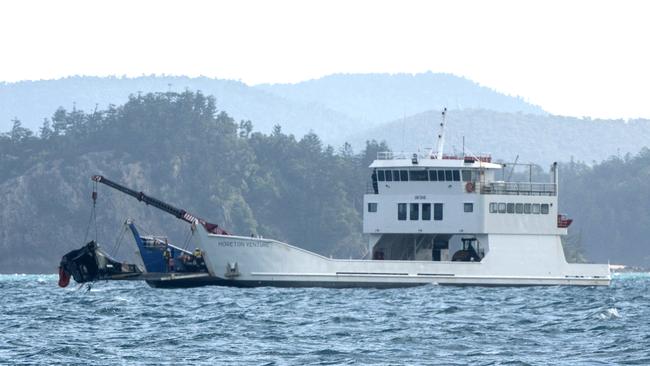 A barge anchored at the site where a MRH 90 military helicopter crashed, lifts out the tail section. in the Whitsundays while carrying four Australians. Picture:Michaela Harlow