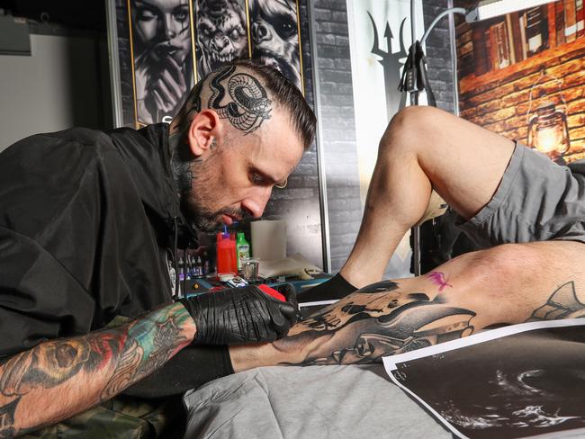 Once you get a tattoo it’s not easy to have it removed if you change your mind. Artist Elric Gordon at work at the expo. Picture: Alex Coppel