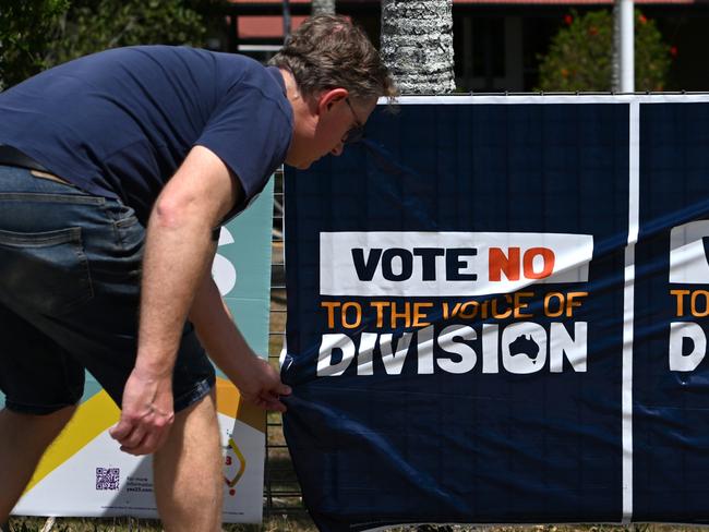 BRISBANE, AUSTRALIA - NewsWire Photos - OCTOBER 14, 2023. A man straightens a No campaign sign as he arrives at a polling place in Brisbane to vote in the Voice referendum. VOICEREF23Picture: Dan Peled / NCA NewsWire