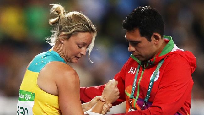 Kim Mickle is attended to by medical staff after dislocating her shoulder in the women’s javelin at the Rio Games.