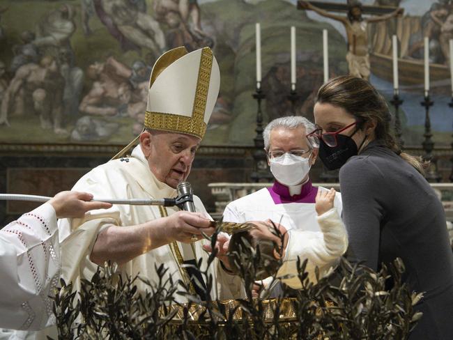 Pope Francis baptising a child during the Holy Mass in the Sistine Chapel in Vatican. The pontiff says getting jabbed is an “act of love”. Picture: AFP