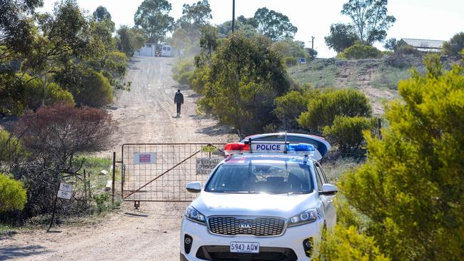 SA Police undertaking a large-scale search of a property in the Murray Mallee with an excavator in a bid to locate evidence believed to be linked with two murder inquiries, Wednesday, September 18, 2019. Police guard the front gate of the property. (Pic: AAP/Brenton Edwards)