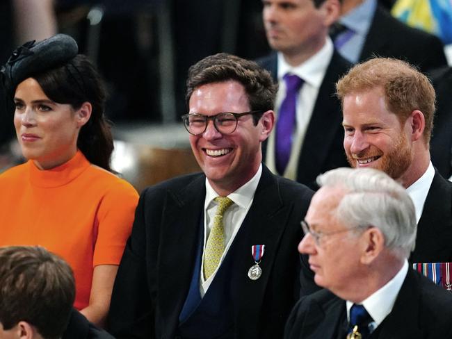 Princess Eugenie of York, Jack Brooksbank and Prince Harry share a lighter moment. Picture: AFP