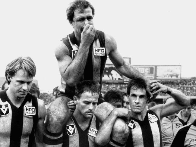 Wallace (right) helps carry Leigh Matthews from the ground after his last game for the Hawks - the 1985 grand final.