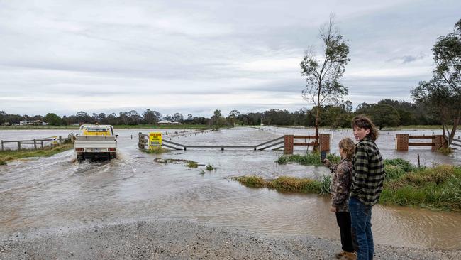 Flooding around the Macalister River flowing out of Lake Glenmaggie. A farmer drives through their flood water. Picture: Jason Edwards