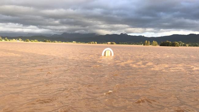 The Murwillumbah winning post pokes through the floodwater. Photos: Jesse Graham and Bella Rabjones.