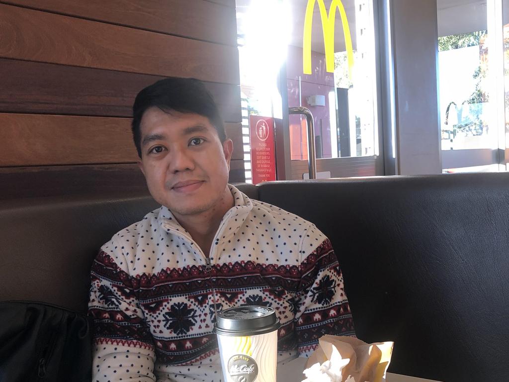 Andy Ang at the airport McDonalds on Saturday morning after waking up in his Mascot Towers unit to find himself the only person left in the building. Picture: Andy Ang