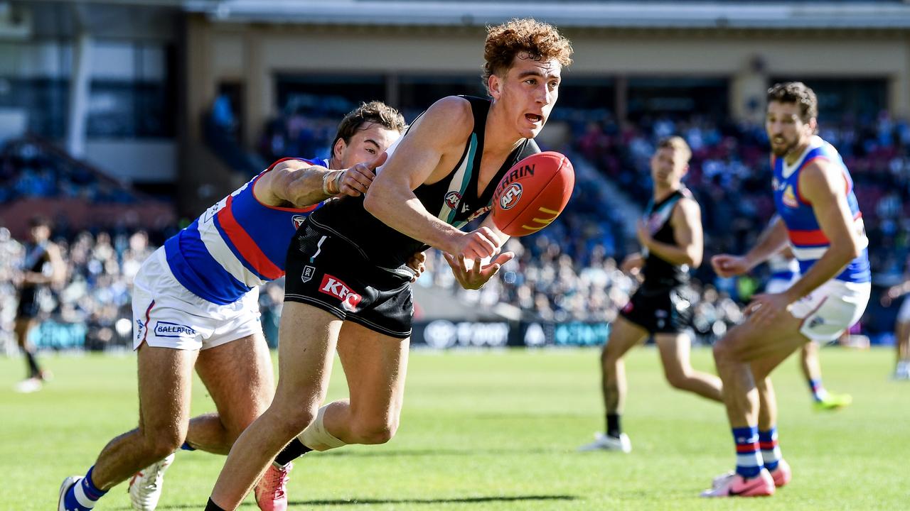 ADELAIDE, AUSTRALIA - JULY 06: Logan Evans of the Power  handballs  tackled by   Lachlan McNeil of the Bulldogs during the round 17 AFL match between Port Adelaide Power and Western Bulldogs at Adelaide Oval, on July 06, 2024, in Adelaide, Australia. (Photo by Mark Brake/Getty Images)