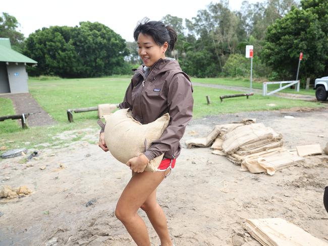 Byron Bay resident Gibby carries a sandbag to take home. Picture: Rohan Kelly