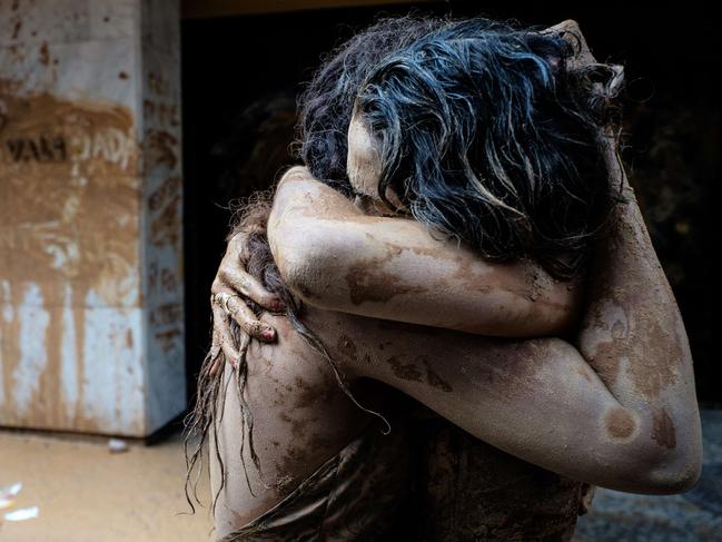 Protesters embrace after throwing muddy water on the façade of Brazilian mining company Vale headquarters in Rio de Janeiro, Brazil, on November 16, 2015. The bursting of two dams at a mine operated by Brazilian company Samarco - equally owned by Vale and Australian BHP Billiton- unleashed torrents of waste that flattened a village in Minas Gerais State on November 5 killing ten people. Brazilian mining firm Samarco promised Monday to pay at least $260 million for damage from the bursting, prosecutors said. AFP PHOTO / YASUYOSHI CHIBA