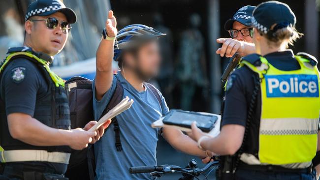 A deliver rider gestures as he speaks to police. Picture: Jason Edwards