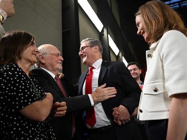 Britain's Labour Party leader Keir Starmer holding hands with his wife Victoria is congratulated by former Labour Party leader Neil Kinnock during a victory rally at the Tate Modern. Picture: AFP